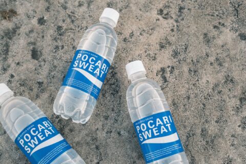 Three Pocari Sweat bottles arranged on a textured concrete surface.