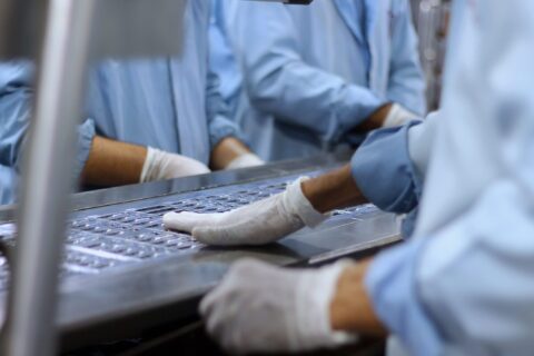 Workers in a pharmaceutical facility packaging tablets in Islamabad.